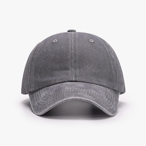 May include: A solid charcoal gray baseball cap with a distressed, washed-out fabric texture. The cap features a six-panel construction with a curved brim, stitched eyelets on the crown, and visible tonal stitching along the front visor panels.
