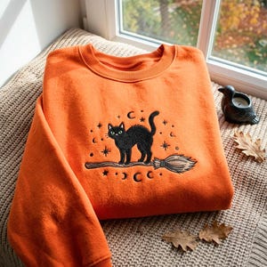 Besticktes Sweatshirt mit schwarzer Katze auf dem Broomstick