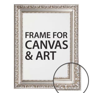 May include: Ornate silver picture frame with the text "FRAME FOR CANVAS & ART" in black. The frame features a detailed, textured design around the edges, suitable for displaying artwork or canvas prints.