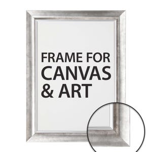 May include: Silver-colored picture frame with the text "FRAME FOR CANVAS & ART" in bold black letters. The frame has a textured finish and a white interior. A close-up of the frame's corner is in the lower right.
