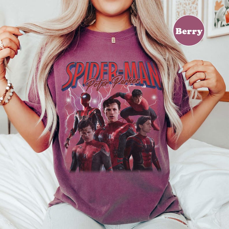 May include: Berry-coloured t-shirt featuring a graphic of Spider-Man and the text "Spider-Man Peter Parker". The design includes multiple images of Spider-Man in action poses, with a lightning bolt background.