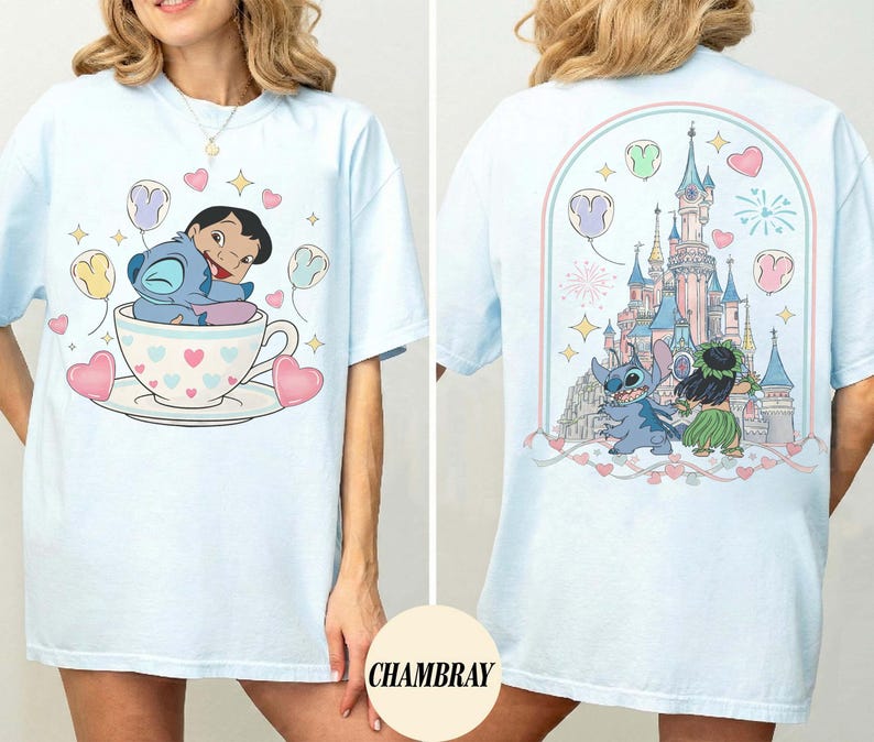 Puede incluir: Camiseta azul claro con un dise&ntilde;o de dibujos animados de un personaje en una taza de t&eacute; con globos y corazones. La parte posterior de la camiseta muestra un castillo, fuegos artificiales y personajes. La palabra "CHAMBRAY" est&aacute; impresa en la parte inferior derecha.