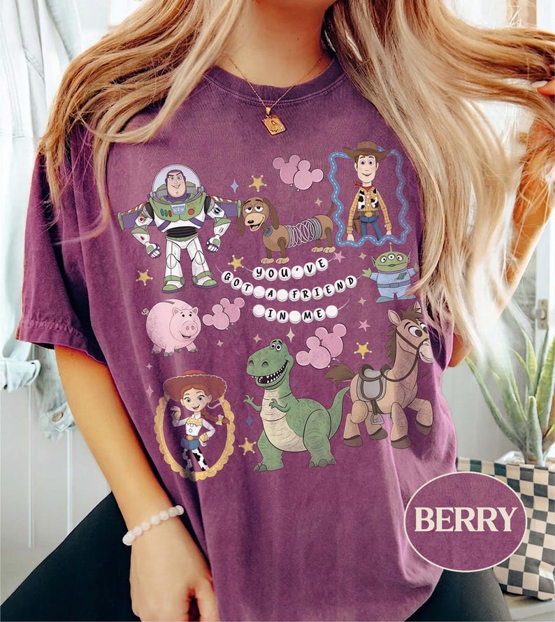 Pu&ograve; includere: T-shirt color bacca con personaggi dei cartoni animati di Toy Story. Il design include Buzz Lightyear, Woody, Jessie, Rex, Hamm, Slinky Dog, Bullseye e un alieno, con la scritta "You've Got a Friend in Me."