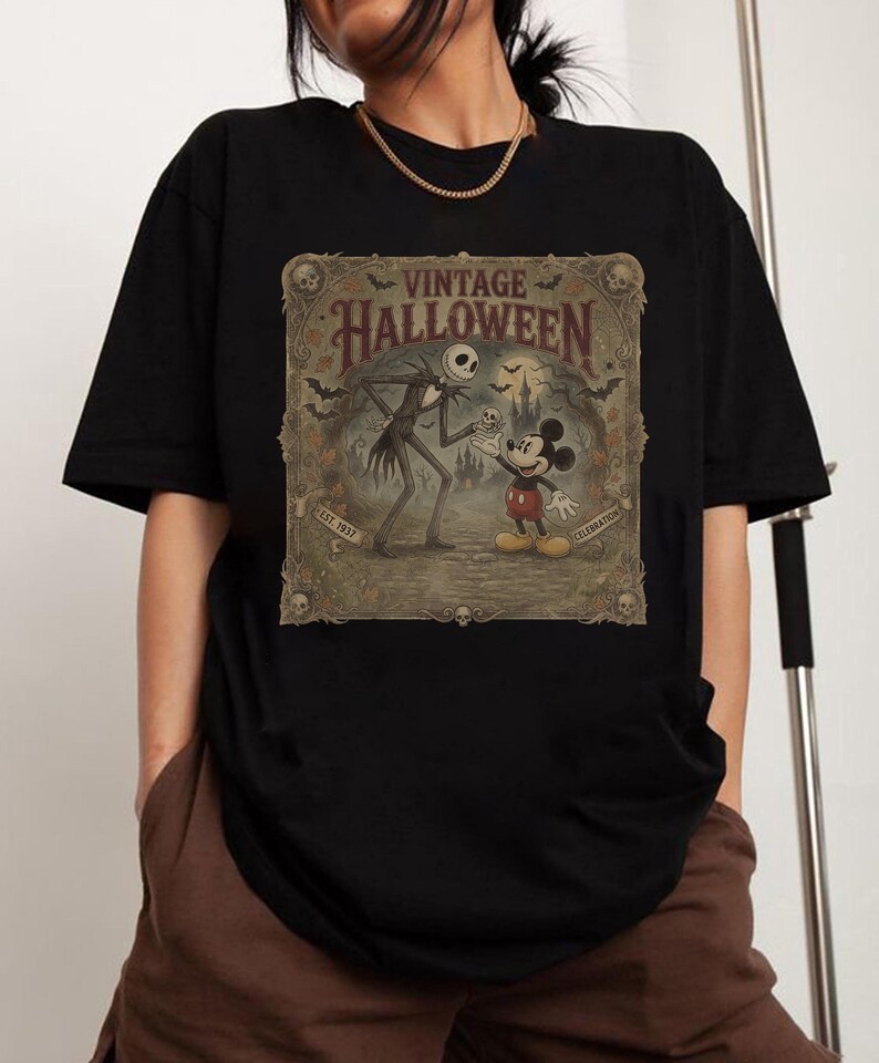 May include: A black short-sleeve t-shirt featuring a rectangular graphic print with the text VINTAGE HALLOWEEN, EST. 1937, and CELEBRATION. The illustration depicts a tall skeletal figure and a mouse character in a spooky landscape with bats.
