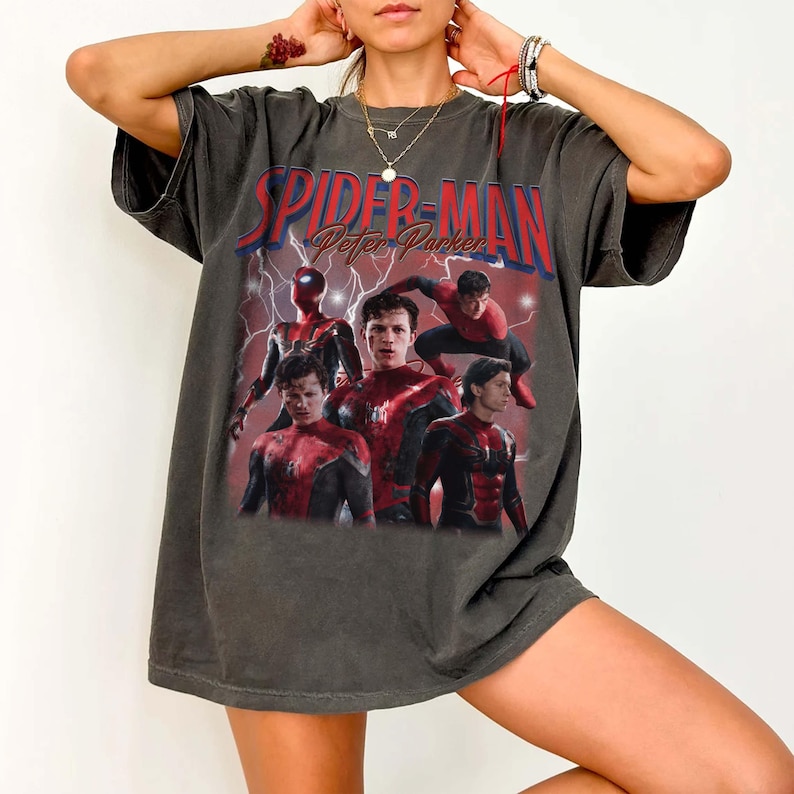 May include: Dark grey t-shirt with a graphic of Spider-Man and the text "Spider-Man Peter Parker" in red and white. The graphic shows multiple images of Spider-Man in action poses against a red lightning background.