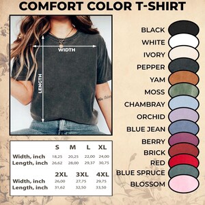Puede incluir: Se muestra una camiseta Comfort Color de color gris oscuro. La imagen muestra opciones de tama&ntilde;o y color, incluyendo negro, blanco, marfil, pimienta, &ntilde;ame, musgo, chambray, orqu&iacute;dea, vaquero azul, baya, ladrillo, rojo, abeto azul y flor. Las medidas est&aacute;n en pulgadas.