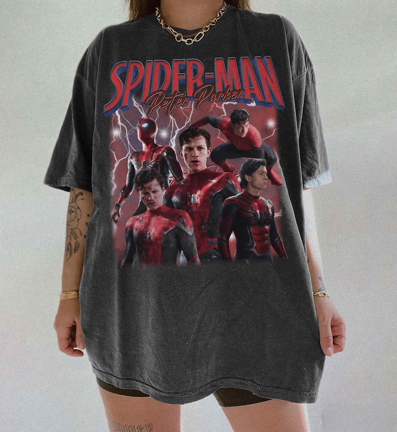 May include: Dark grey t-shirt with a graphic of Spider-Man and the text "Spider-Man Peter Parker" in red and blue. The graphic shows multiple images of Spider-Man in his suit against a red lightning background.
