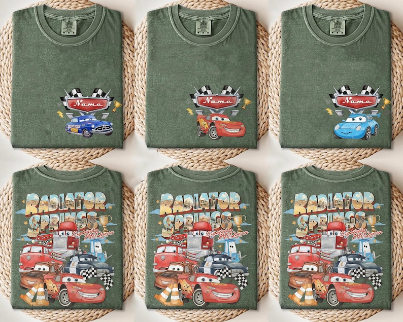 May include: Green t-shirts with car-themed designs. Some shirts feature a race car design with a name banner, while others display the text "Radiator Springs" with various car illustrations. The shirts are displayed on woven mats.
