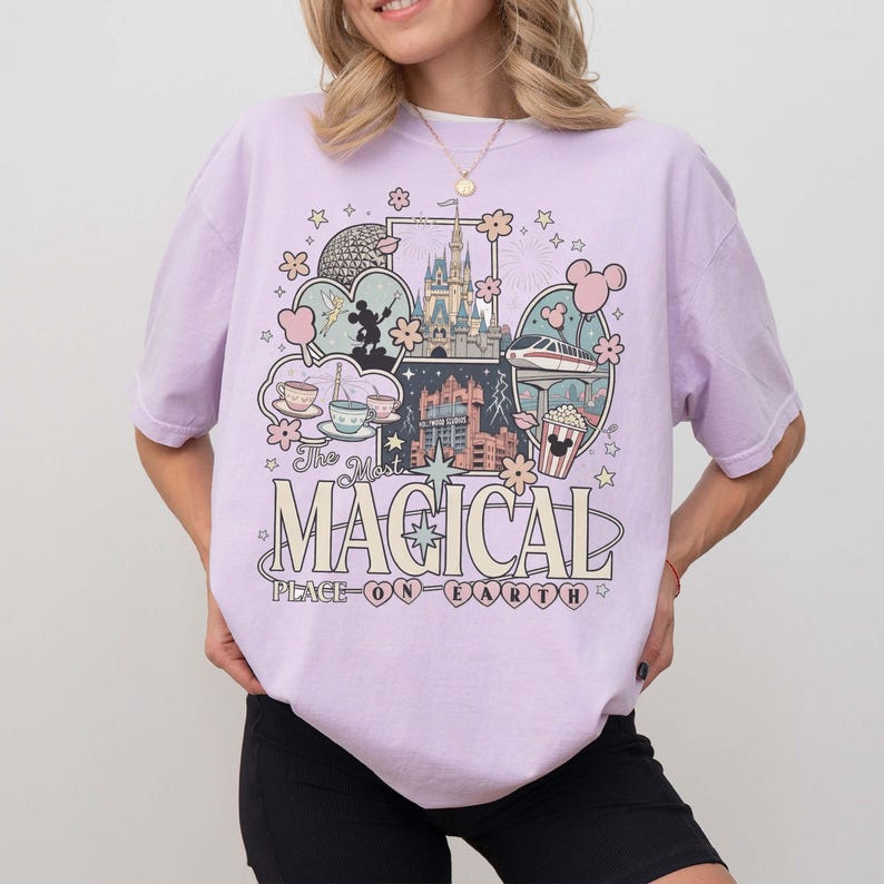 Puede incluir: Una camiseta de color lila claro con un dise&ntilde;o gr&aacute;fico que presenta un castillo, Mickey Mouse y el texto "The Most Magical Place on Earth". El dise&ntilde;o incluye varias ilustraciones y estrellas.