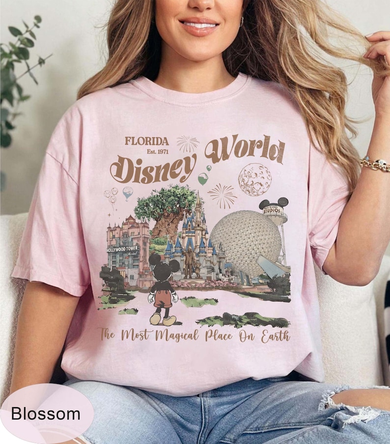 Może przedstawiać: Jasnor&oacute;żowa koszulka z grafiką Disney World na Florydzie. Projekt zawiera napis "Florida Disney World Est. 1971" oraz ilustrację Myszki Miki, Drzewa Życia i Spaceship Earth. Zawiera r&oacute;wnież tekst "The Most Magical Place On Earth".