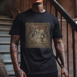 May include: A black short-sleeve t-shirt featuring a graphic print with the text VINTAGE HALLOWEEN. The design depicts a tall skeletal figure and a cartoon mouse character standing in front of a castle silhouette with bats in a sepia-toned frame.