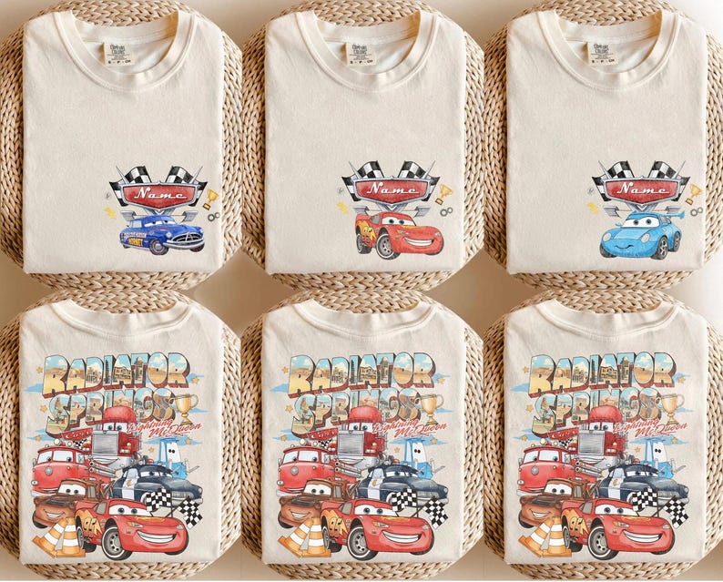 May include: Six cream-coloured t-shirts with colourful car graphics. The top row features individual car designs with a name banner and chequered flags. The bottom row displays a design with multiple cars and the text "Radiator Springs".