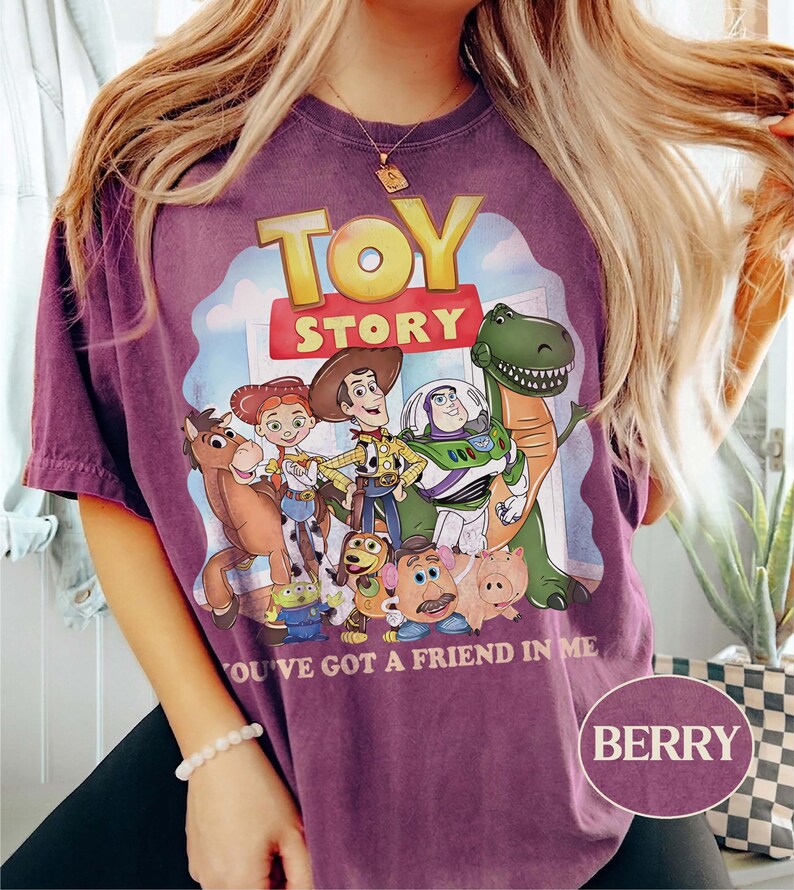 Puede incluir: Camiseta color bayas con un gr&aacute;fico de personajes de la pel&iacute;cula animada "Toy Story". El dise&ntilde;o incluye a Woody, Buzz Lightyear y otros personajes, con el texto "TOY STORY" y "YOU'VE GOT A FRIEND IN ME."