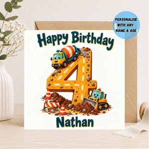 May include: A square birthday greeting card featuring the text Happy Birthday and Nathan. The design includes a large orange number four shaped like a road, a yellow cement mixer truck, a yellow bulldozer, orange traffic cones, and brown dirt.