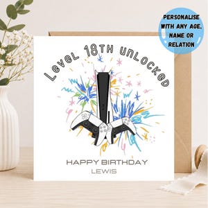Peut inclure: Une carte de vœux carrée blanche avec une console de jeu noire et blanche et deux manettes centrées sur des graphismes de feux d'artifice gribouillés. Le texte indique Level 18TH UNLOCKED, HAPPY BIRTHDAY et LEWIS. Un cercle bleu indique PERSONALIZE WITH ANY AGE, NAME OR RELATION.