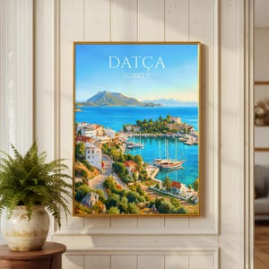Pode incluir: Uma impressão artística emoldurada apresentando uma paisagem costeira de Datça, Turquia. A cena retrata um porto azul com veleiros, edifícios brancos com telhados vermelhos, colinas verdes e montanhas sob um céu limpo. O texto diz DATÇA TURKEY.
