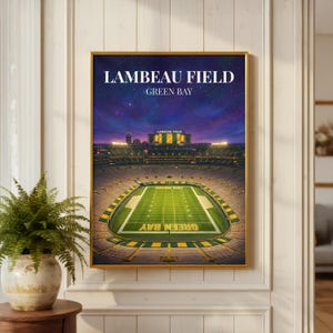 May include: A framed wall art print depicting an aerial view of Lambeau Field in Green Bay at night. The stadium is illuminated with green and yellow seating, a bright green football field, and a deep purple starry sky above the horizon.
