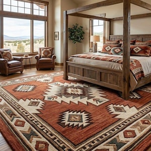 May include: A large rectangular area rug featuring a geometric pattern in shades of rust orange, cream, brown, and dark grey. The rug displays repeating diamond and chevron motifs across its surface, covering the wooden floor in a bedroom.