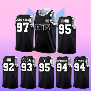 Peut inclure: Une collection de maillots de basket noirs avec des bordures et des inscriptions blanches. Chaque maillot affiche un nom et un numéro à deux chiffres, dont JUNG KOOK 97, JIMIN 95, JIN 92, SUGA 93, V 95, RAP MONSTER 94, J-HOPE 94 et un logo BTS central.