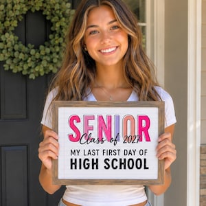 May include: A rectangular wooden sign featuring the text SENIOR in large pink and purple letters, followed by the script text Class of 2027 and the printed text MY LAST FIRST DAY OF HIGH SCHOOL on a white background with faint blue lines.