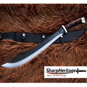 May include: A large, curved sword with a polished steel blade and a dark wooden handle. The sword is on a black leather sheath, with the "SharpHeritage" logo visible. The background is a textured brown surface.