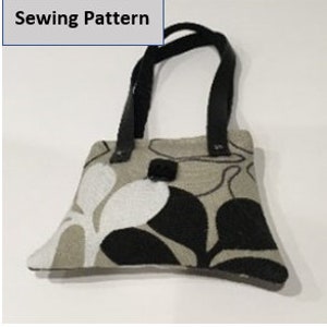 May include: A small, black and white floral patterned fabric handbag with black leather handles.