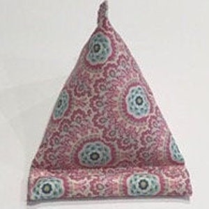 May include: A pink and blue patterned triangular pillow with a decorative design. The pillow is filled with stuffing and can be used to prop up a book or tablet.