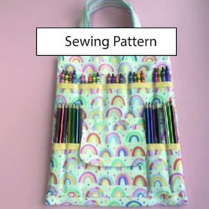 Puede incluir: Una bolsa de tela con estampado de arcoíris con asa y varios bolsillos para guardar lápices de colores y lápices de colores. El texto "Sewing Pattern" está impreso en un rectángulo blanco sobre la bolsa.