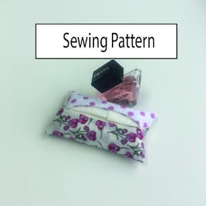 May include: Sewing pattern for a tissue holder with a floral print and white polka dots. The tissue holder is shown with a small bottle of perfume.