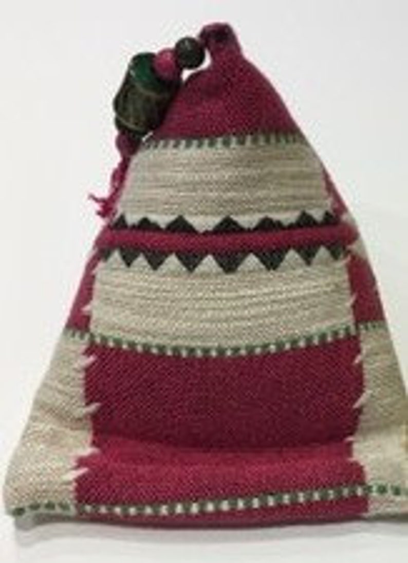 May include: A small, triangular, red and beige patterned fabric pouch with a green and brown wooden bead at the top.