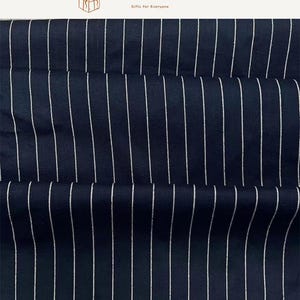 May include: A dark navy blue fabric featuring a repeating pattern of thin, vertical white pinstripes. The textile has a visible woven texture and is displayed with soft folds. The top of the image includes the text SEARCHANDSHOP Gifts for Everyone.