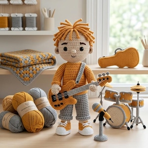 May include: A crocheted doll with mustard yellow hair, wearing a mustard yellow long-sleeve shirt and gray pants, holding a mustard yellow bass guitar. The doll is accompanied by a miniature crocheted drum set, a microphone, and a guitar case.