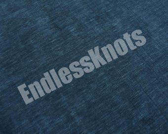 Könnte beinhalten: Ein dunkelblauer Stoff mit melierter Textur, auf dem der Text EndlessKnots in einer hellgrauen, serifenlosen Schrift diagonal über die Mitte des Materials gedruckt ist. Das Textil weist ein durchgehendes Webmuster auf der gesamten Oberfläche auf.