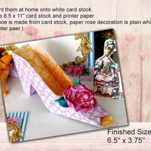 May include: A 3D papercraft shoe with a pink and white patterned design. The shoe has a pink rose decoration and a yellow interior. The finished size is 6.5 inches by 3.75 inches.
