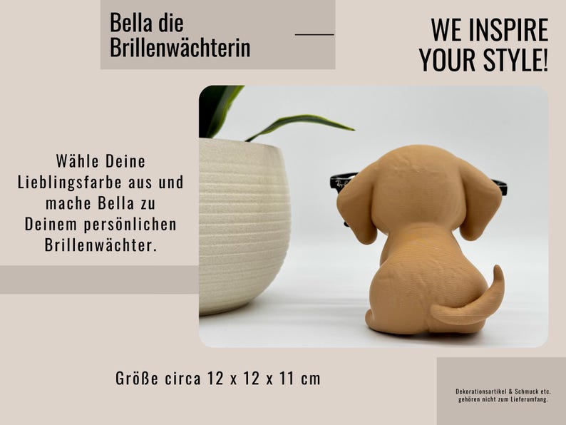 May include: A tan puppy ornament wearing glasses, with the text "WE INSPIRE YOUR STYLE!" and "Bella die Brillenw&auml;chterin." The ornament is approximately 12 x 12 x 11 cm. A decorative item.