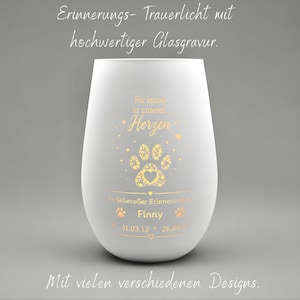 May include: A frosted white glass memorial candle holder featuring gold-toned engraving. The text reads "Für immer in unseren Herzen", "In liebevoller Erinnerung an", "Finny", and the dates "31.03.13" and "26.09.23" with a paw print graphic.