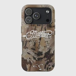 K&ouml;nnte beinhalten: Sch&uuml;tzende Handyh&uuml;lle mit Tarnmuster in Braun-, Beige- und Gr&uuml;nt&ouml;nen. Die H&uuml;lle zeigt den wei&szlig;en Text "Mathews" mit einem Pfeildesign. Die H&uuml;lle hat drei Kameralinsen und einen Blitz.