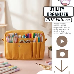 Peut inclure: Un organisateur utilitaire en tissu jaune moutarde avec plusieurs poches extérieures remplies de stylos, marqueurs et rouleaux de ruban adhésif colorés. Le texte indique : sewing grid, UTILITY ORGANIZER, PDF Pattern, Video Tutorial, Photo Tutorial, Beginner Friendly, Easy Instructions, Easy to Sew, A4, A3 and Full scale, INSTANT DOWNLOAD.
