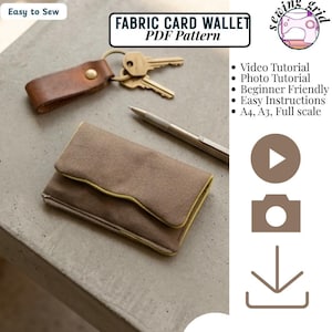 May include: A brown fabric card wallet PDF pattern with text reading FABRIC CARD WALLET PDF Pattern, Easy to Sew, Video Tutorial, Photo Tutorial, Beginner Friendly, Easy Instructions, A4, A3, Full scale, and Instant Download, with a key fob and pen.