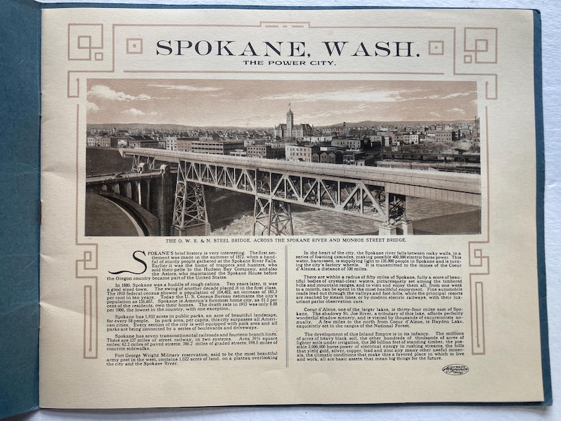 Op de afbeelding: Een zwart-witfoto van een stalen brug over een rivier in Spokane, Washington. De bijschrift luidt "The O.W.K.&N. Steel Bridge, across the Spokane River and Monroe Street Bridge." De tekst onder de foto beschrijft de geschiedenis van Spokane, Washington, en de groei ervan als stad.