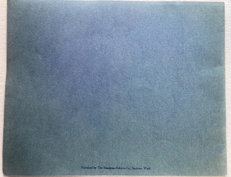 Op de afbeelding: Een blauw papieren boekje met de tekst "Published by The Boughton-Robbins Co., Spokane, Wash." onderaan.