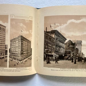 Op de afbeelding: Een vintage zwart-witfoto van een straat in de stad met gebouwen en auto's. De bijschrift luidt "Riverside Avenue, de belangrijkste winkelstraat van de stad. De straten van Spokane zijn breed en vlak, de rots waarop de stad is gebouwd, helpt om haar natuurlijke voordelen te vormen."