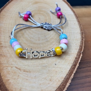 HOPE adjustable drawstring bracelet in pastel beads and the word Hope in silver.