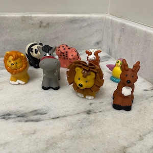 May include: A collection of colorful toy animal figurines, including a lion, panda, horse, leopard, cow, parrot, and deer. The lion has a yellow face and brown mane. The figurines are made of plastic and are designed for children.