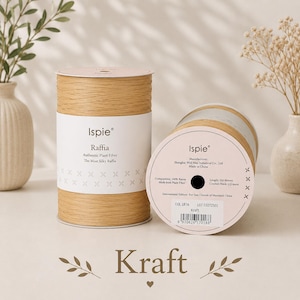 May include: Two cylindrical spools of light brown Ispie Raffia plant fiber yarn. The white label displays the brand name, product details, 250 meters length, and 2.5-4mm crochet hook recommendation. The color is labeled as Kraft with a barcode.