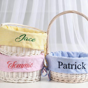 Op de afbeelding: Wicker paasmanden met gingham stoffen voeringen in geel, roze en blauw. Elke mand heeft een naam geborduurd op de voering: Jace, Tommie en Patrick. De manden hebben een geweven handvat.