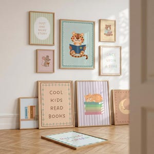 May include: A collection of ten framed wall art prints featuring illustrations of animals, books, and text including "Just One More Story," "Once Upon a Time," "Cool Kids Read Books," and "Reading Corner" in various pastel colours and wooden frames.