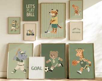 May include: A gallery wall set of nine framed prints featuring illustrations of animals playing sports, including a tiger golfing, a rhino with a baseball bat, a bear playing soccer, and a giraffe with a basketball, with text reading LET'S PLAY BALL, GOAL, and LONG LIVE BOYHOOD.