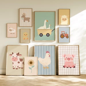 May include: A collection of ten framed wall art prints featuring illustrations of farm animals including a goat, sheep, duck, chick, cow, chicken, and pig, alongside a sunflower and a tractor, arranged in a gallery wall display on a wall.