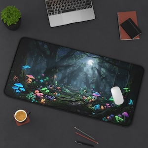 Puede incluir: Alfombrilla de escritorio rectangular con una escena de bosque de fantasía. El diseño presenta setas brillantes y coloridas, una luna llena y árboles. También se ven un ratón, un portátil, una taza de café y un cuaderno.